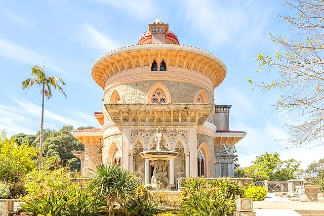 De Moors getinte gevel van het Paleis van Monserrate met koepelrotonde en fontein onder een blauwe hemel