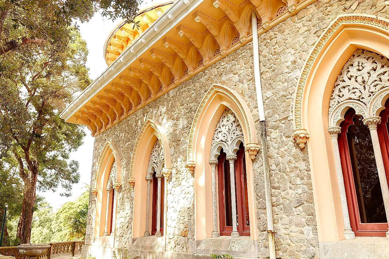 Geschnitzte maurisch inspirierte Fenster und ein Zackengesims an den sonnenbeschienenen Mauern des Monserrate-Palastes