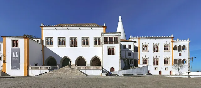 De lange witte voorgevel van het Nationaal Paleis van Sintra onder de twee kegelvormige schoorstenen