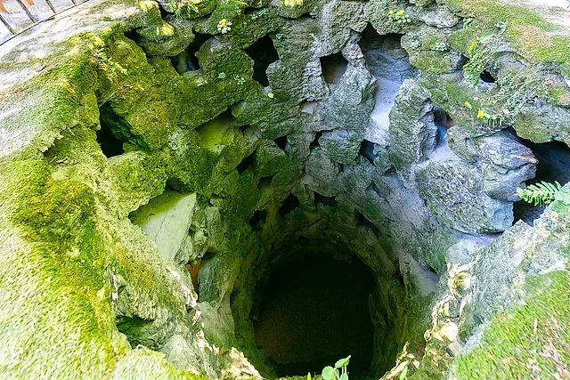 Blik in de Initiatieput van Quinta da Regaleira met zijn met mos bedekte spiraalwanden