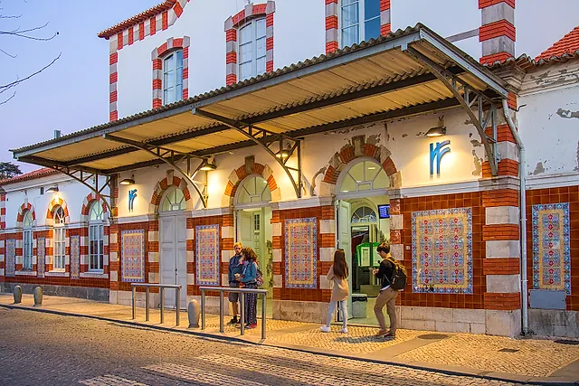 De rood-witte betegelde gevel van het station van Sintra met reizigers ervoor